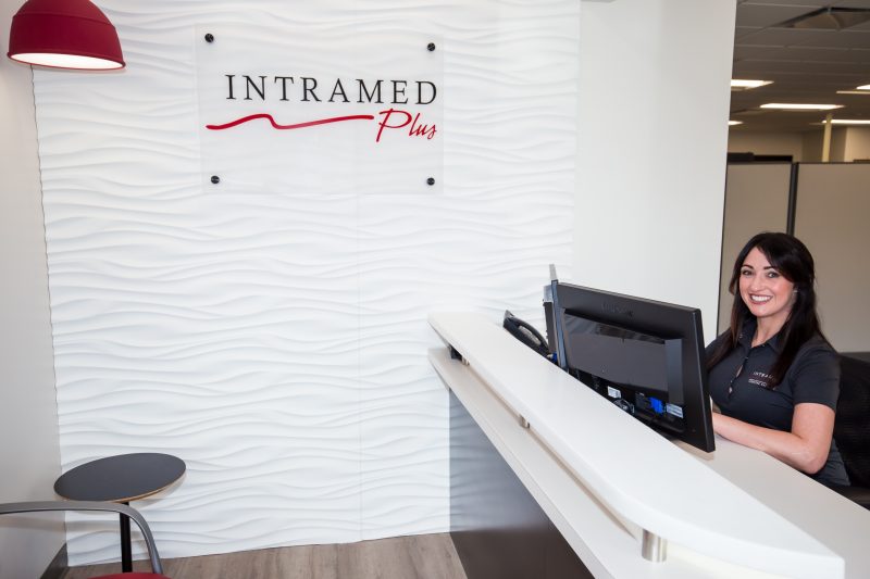 Intramed Plus female employee sitting at desk