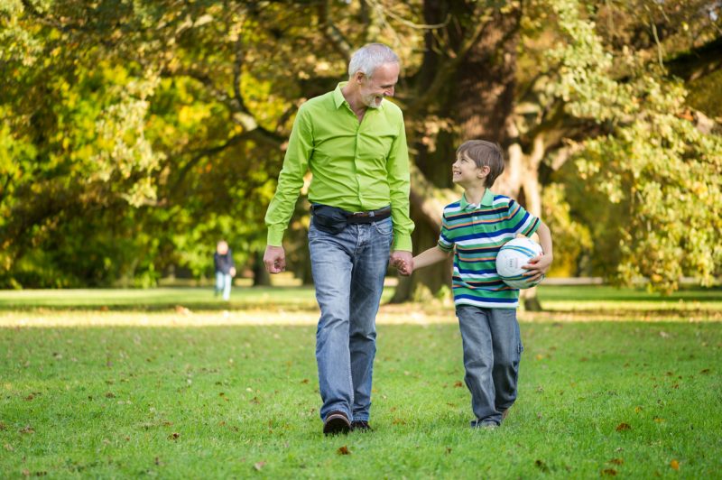 Dad and son walking outside while receiving home infusion therapy
